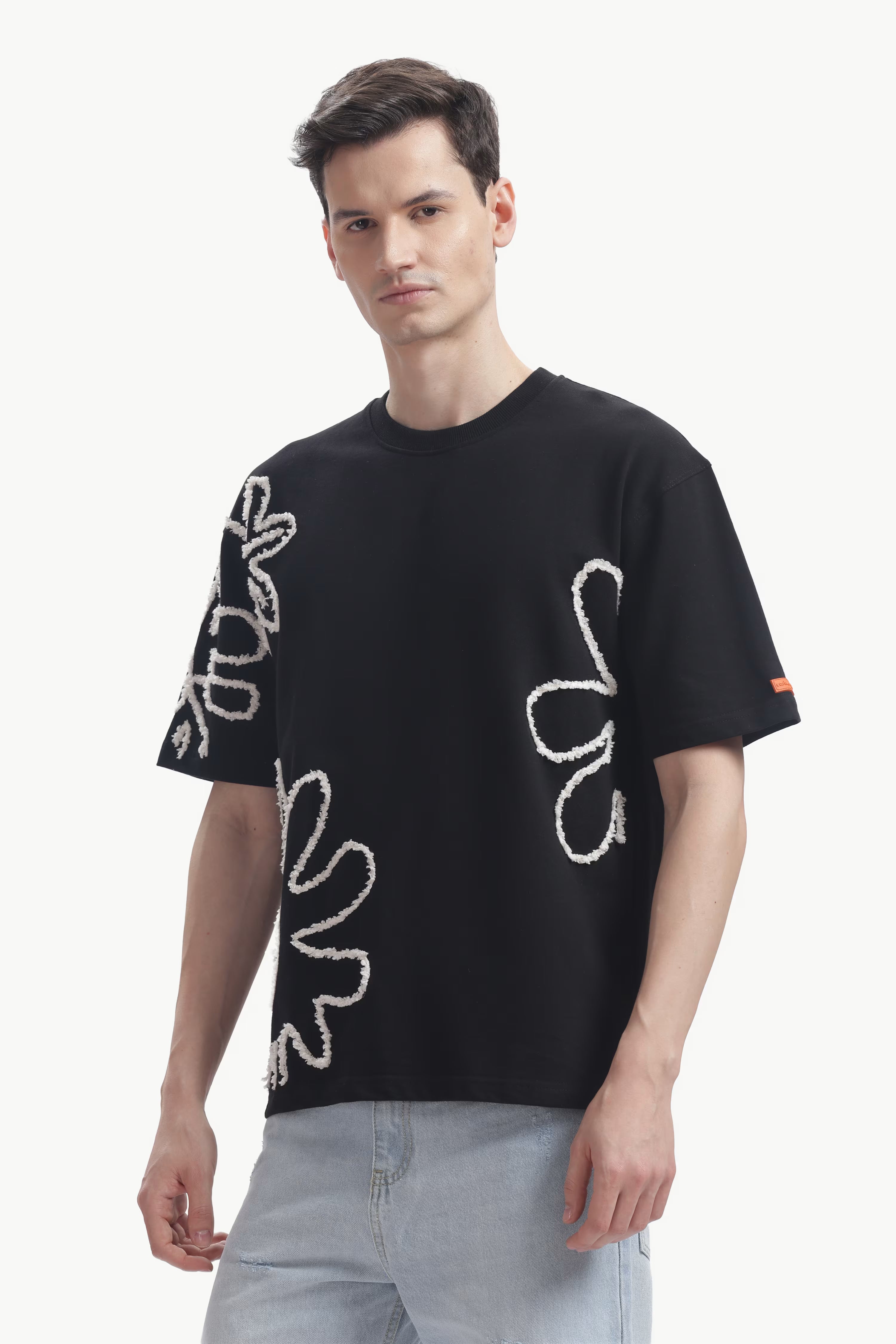 Man wearing a black t-shirt with white designs on a white background