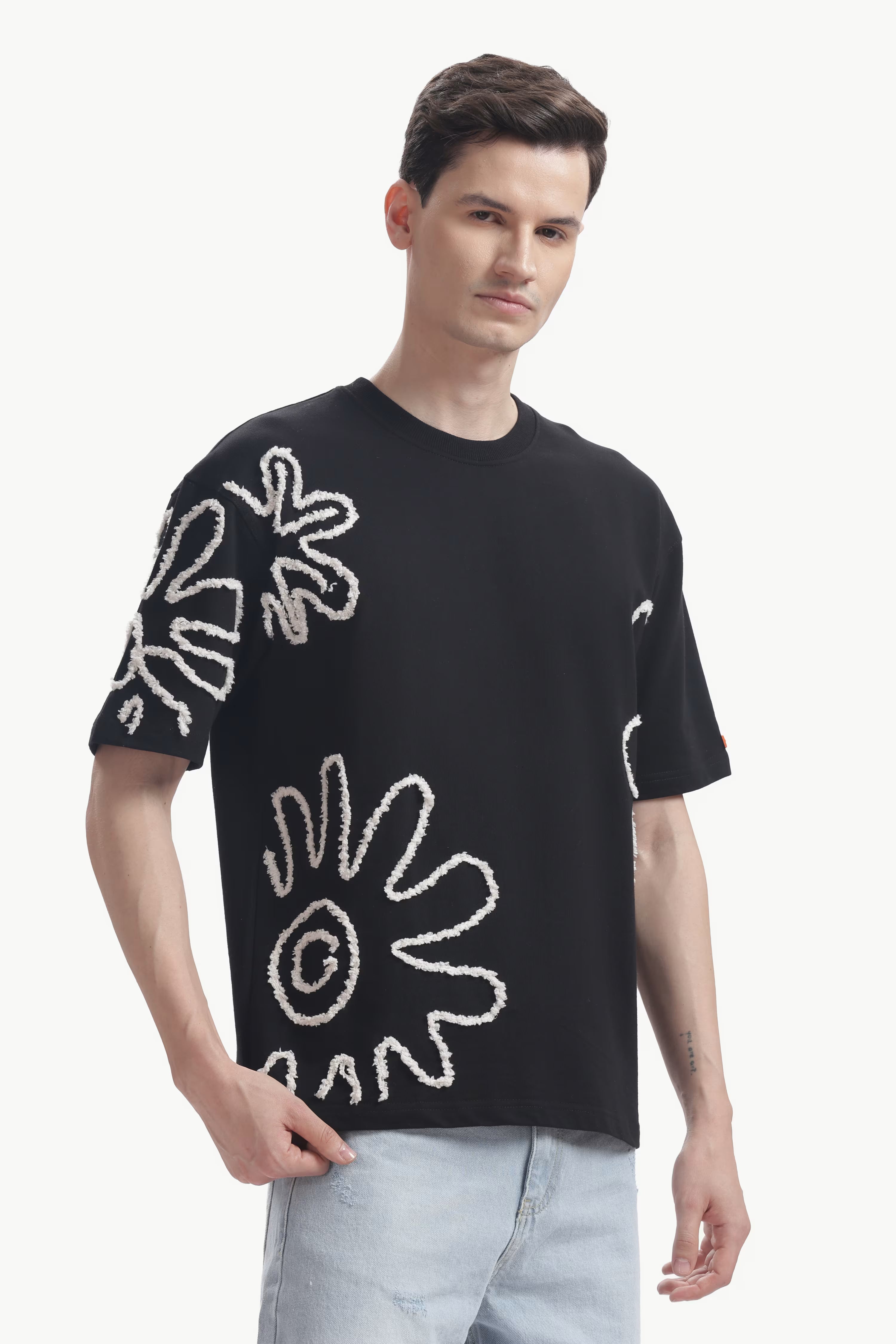 Man wearing a black t-shirt with white abstract designs on a white background