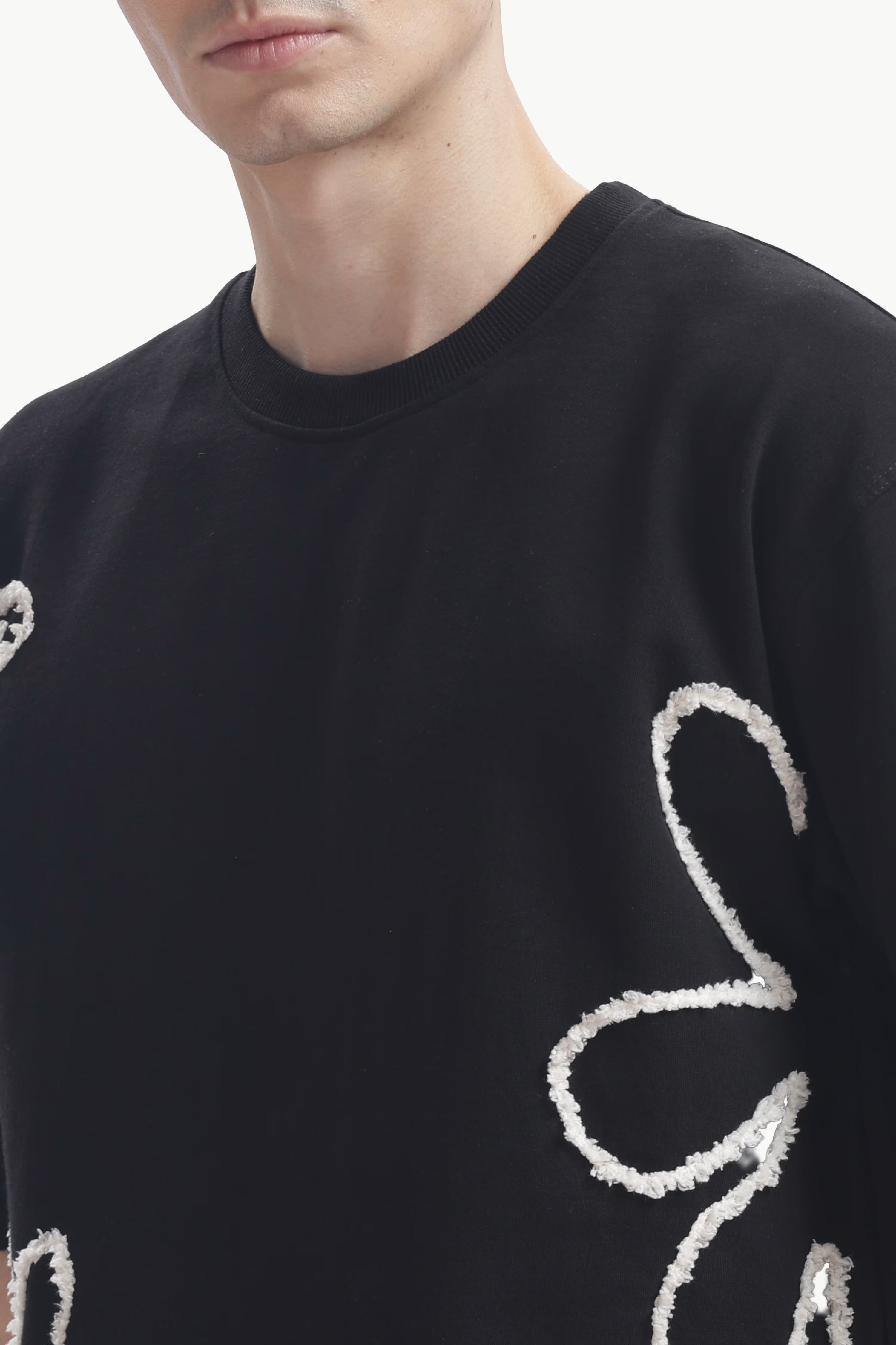 Black sweater with white text and patterns on a white background