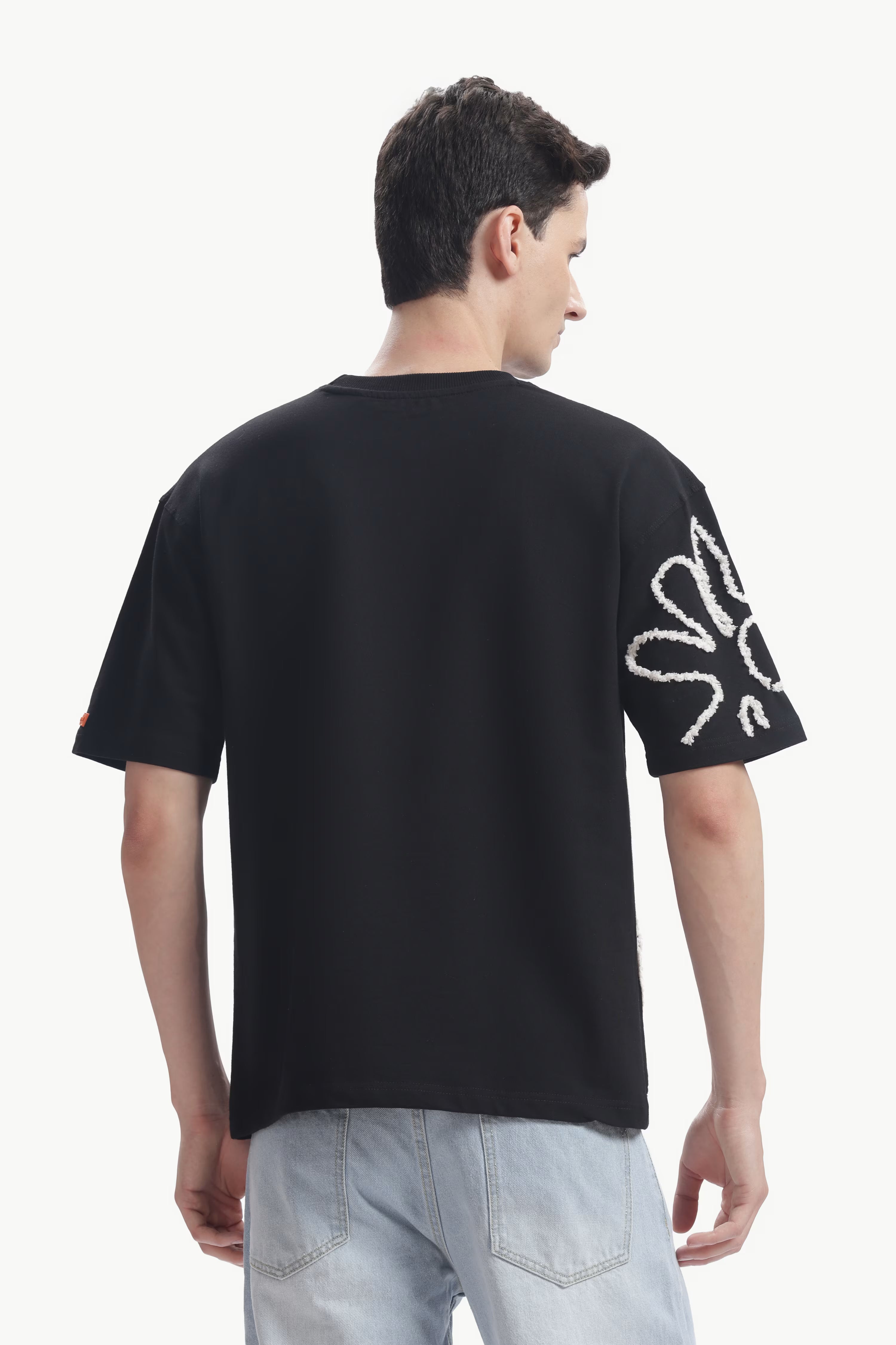 Man wearing a black t-shirt with white graphics on a white background