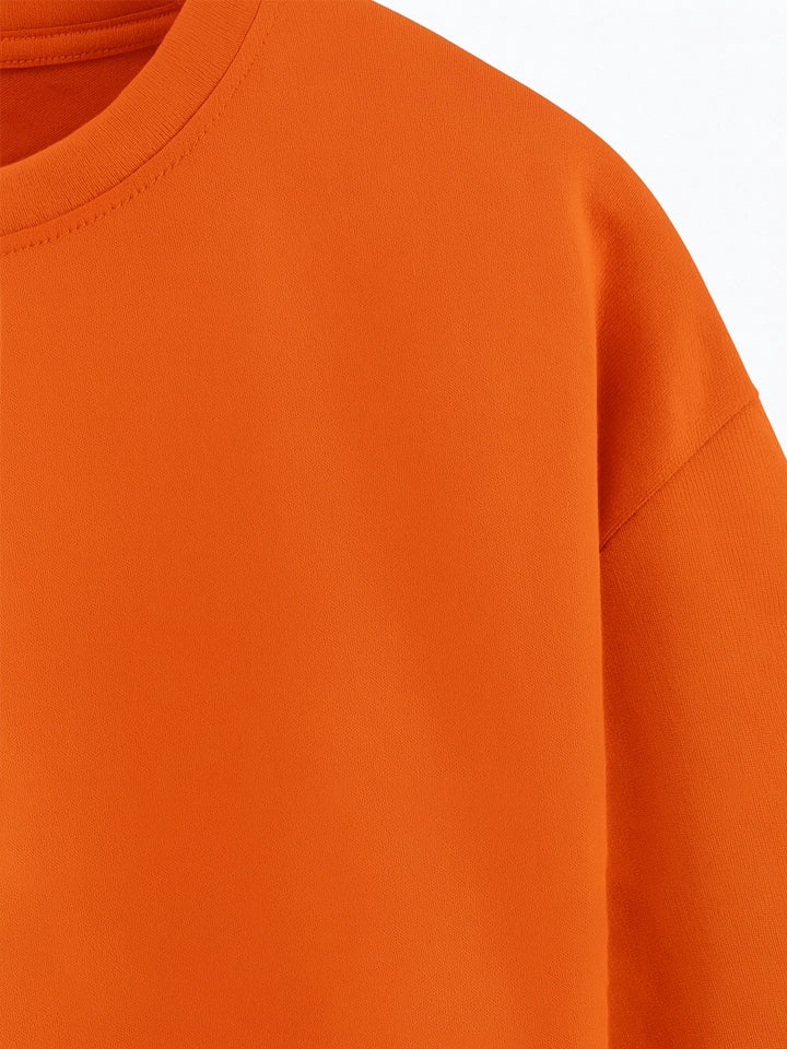 Close-up of an orange sweatshirt on a white background