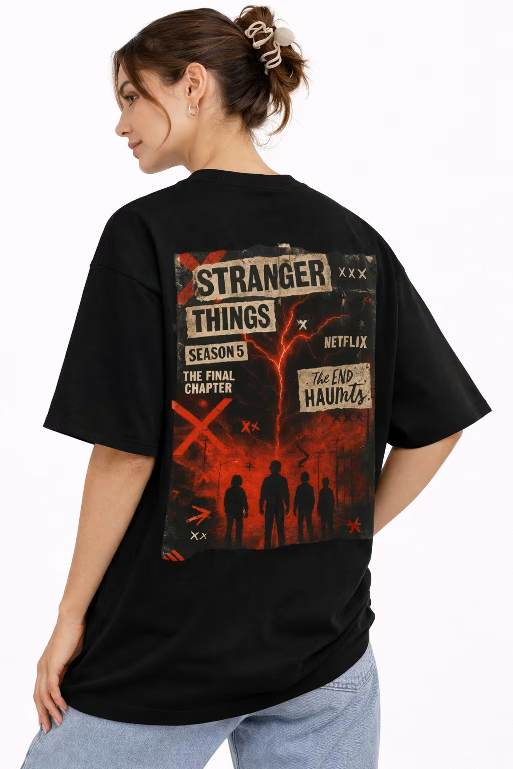 Person wearing a black 'Stranger Things' t-shirt with a graphic design on the back.