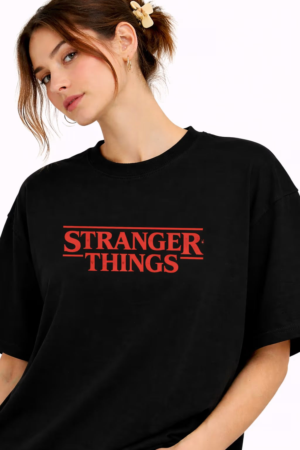 Person wearing a black 'Stranger Things' t-shirt with red text on a white background