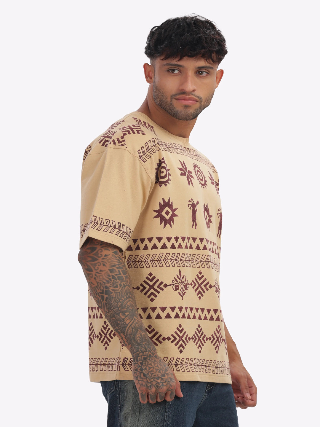 Man wearing a beige t-shirt with brown patterns on a white background