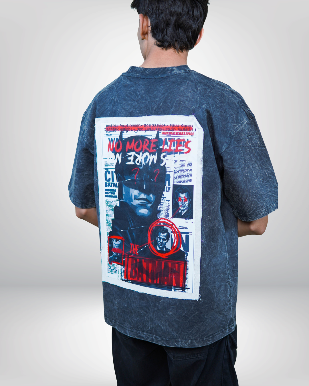 Person wearing a acid grey bat man graphic t-shirt with a prominent design on the back.