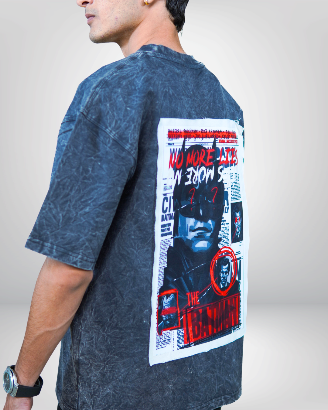 Person wearing a acid grey bat man graphic t-shirt with a prominent design on the back.