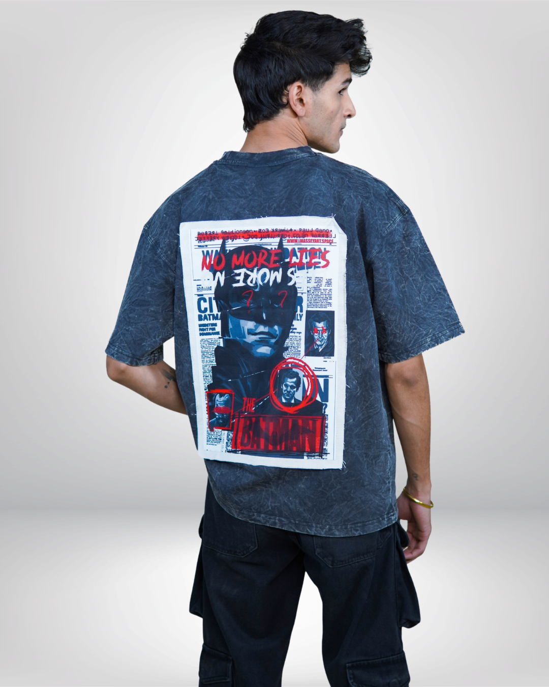 Person wearing a acid grey bat man graphic t-shirt with a prominent design on the back.