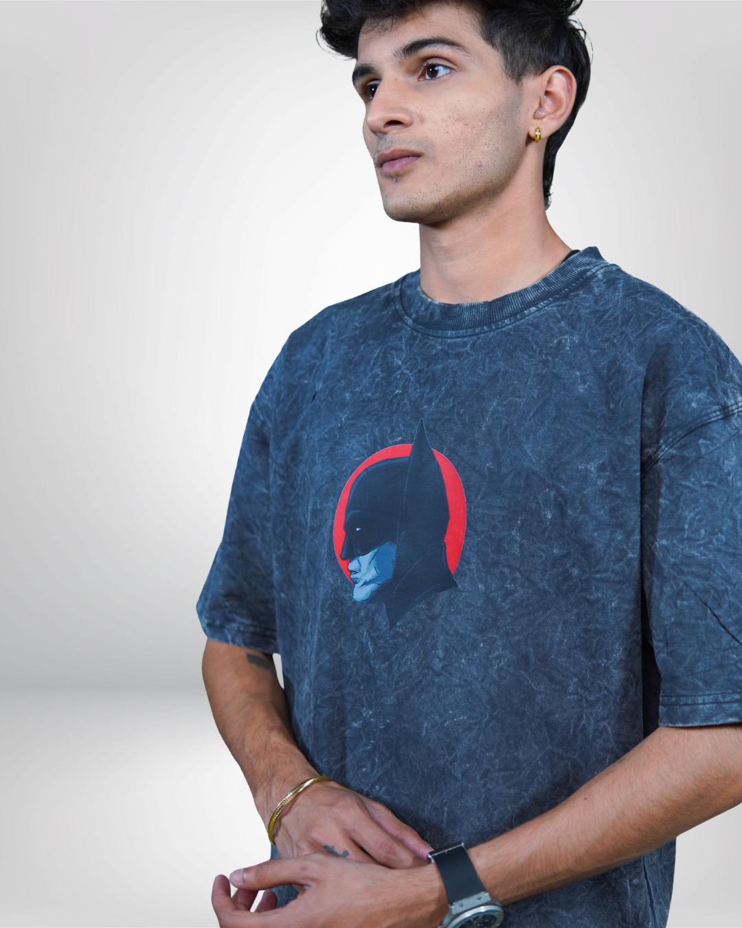 Person wearing a acid grey bat man graphic t-shirt with a prominent design on the back.