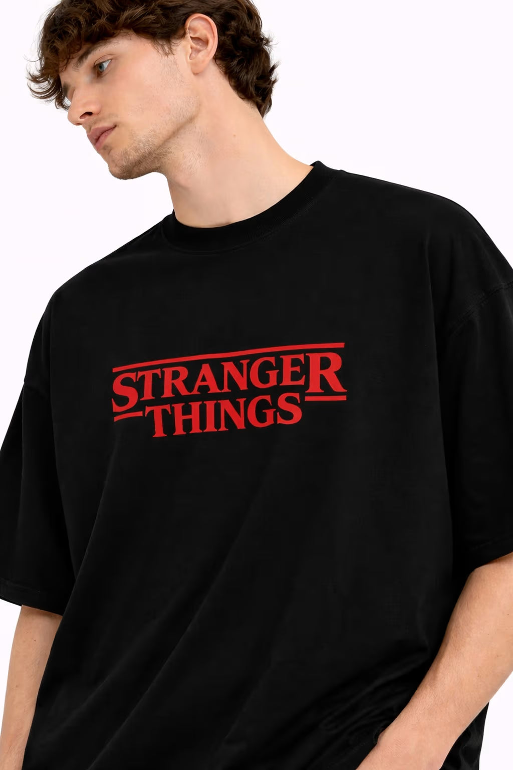 Person wearing a black 'Stranger Things' t-shirt with a graphic design on the back.