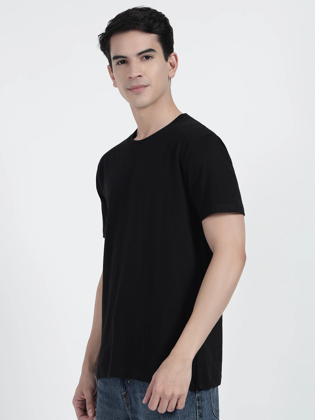 A person standing and holding a basketball, wearing a black plain T-shirt by cartonpanti india