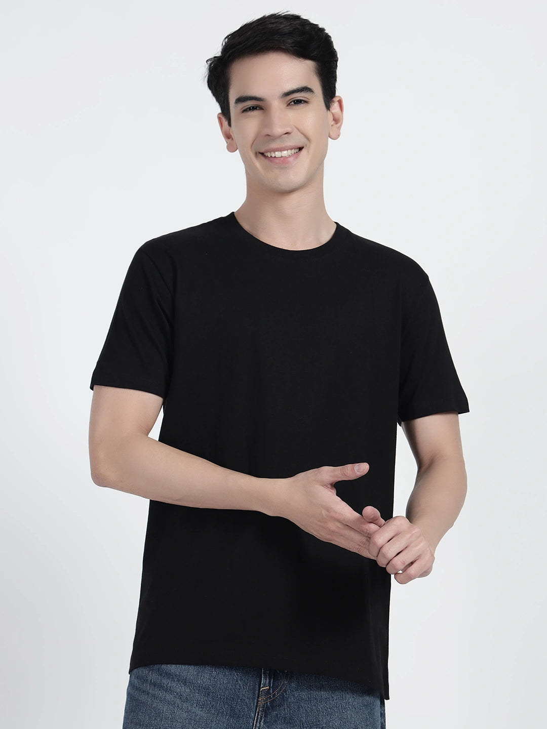 A person standing and holding a basketball, wearing a black plain T-shirt by cartonpanti india