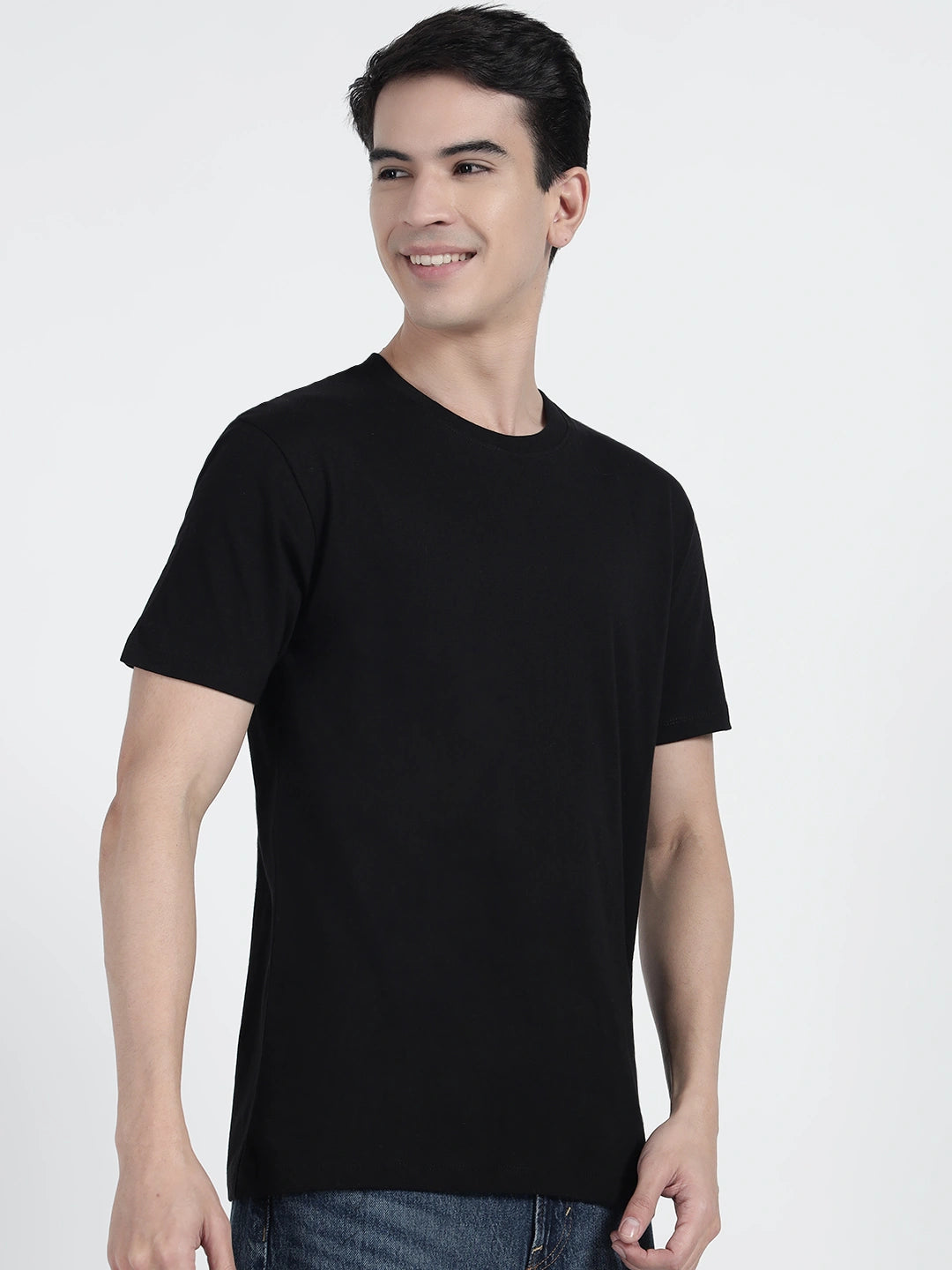 A person standing and holding a basketball, wearing a black plain T-shirt by cartonpanti india
