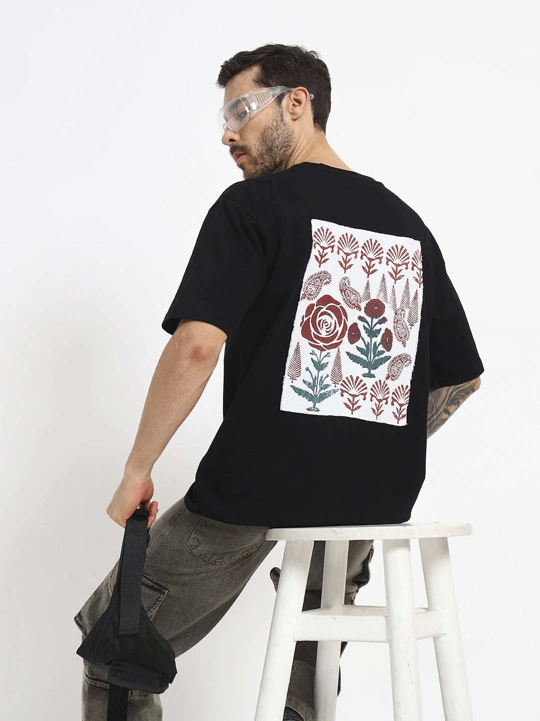 Man wearing a black oversized t-shirt with a floral design  by cartoonpanti  india