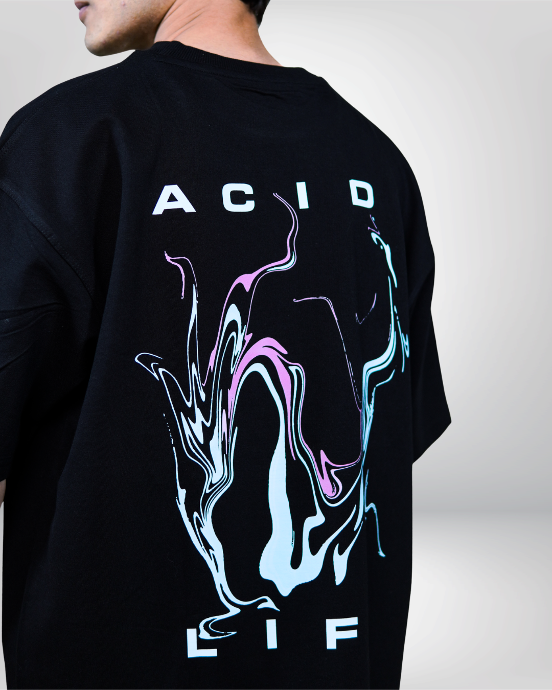 Person wearing a black t-shirt with 'ACID LIFE' text on a plain background