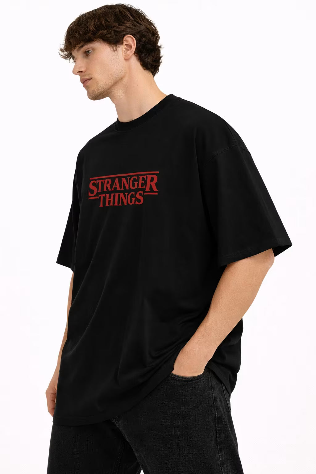 Person wearing a black t-shirt with 'Stranger Things' logo on a white background