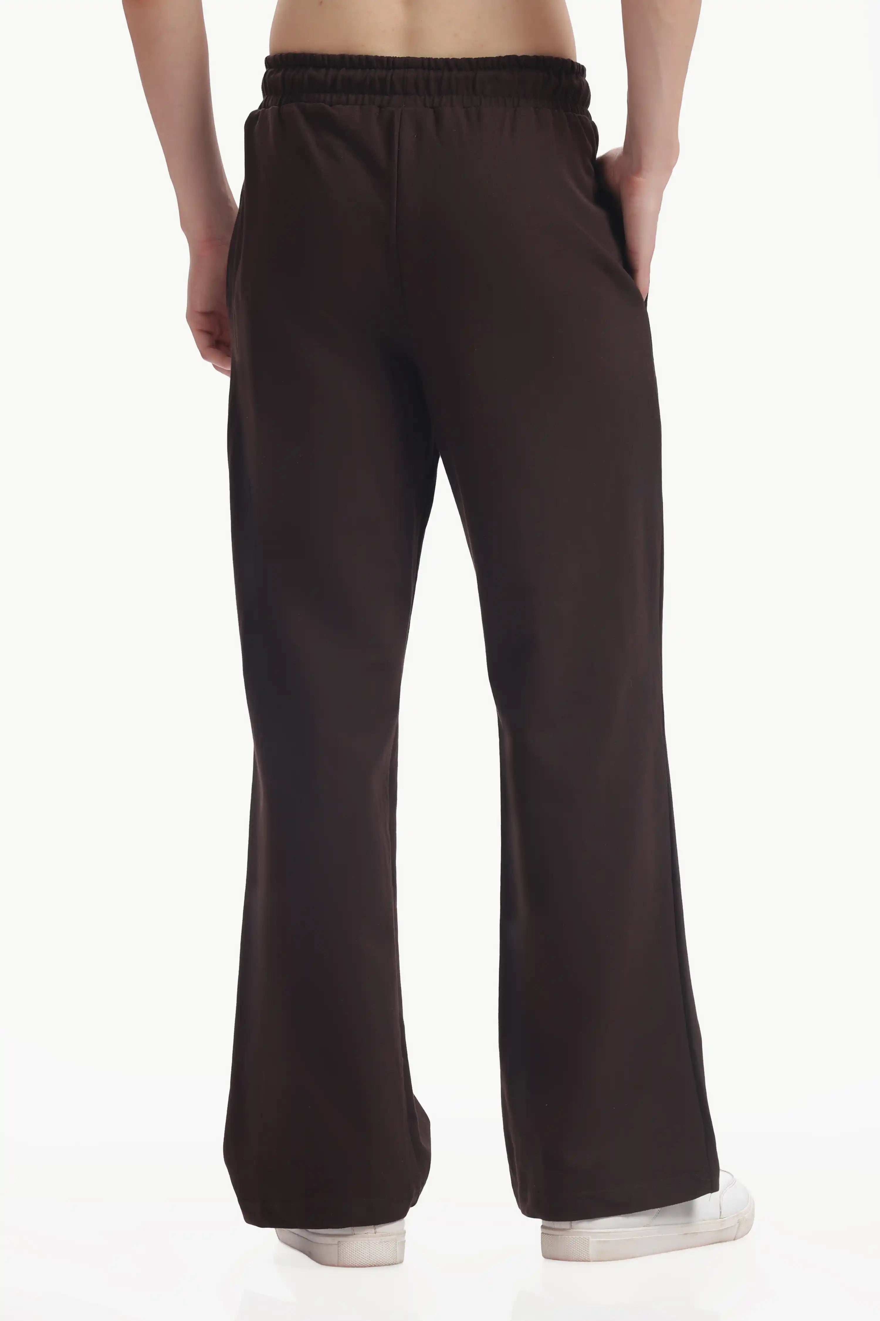 Dark brown pants worn by a person on a white background