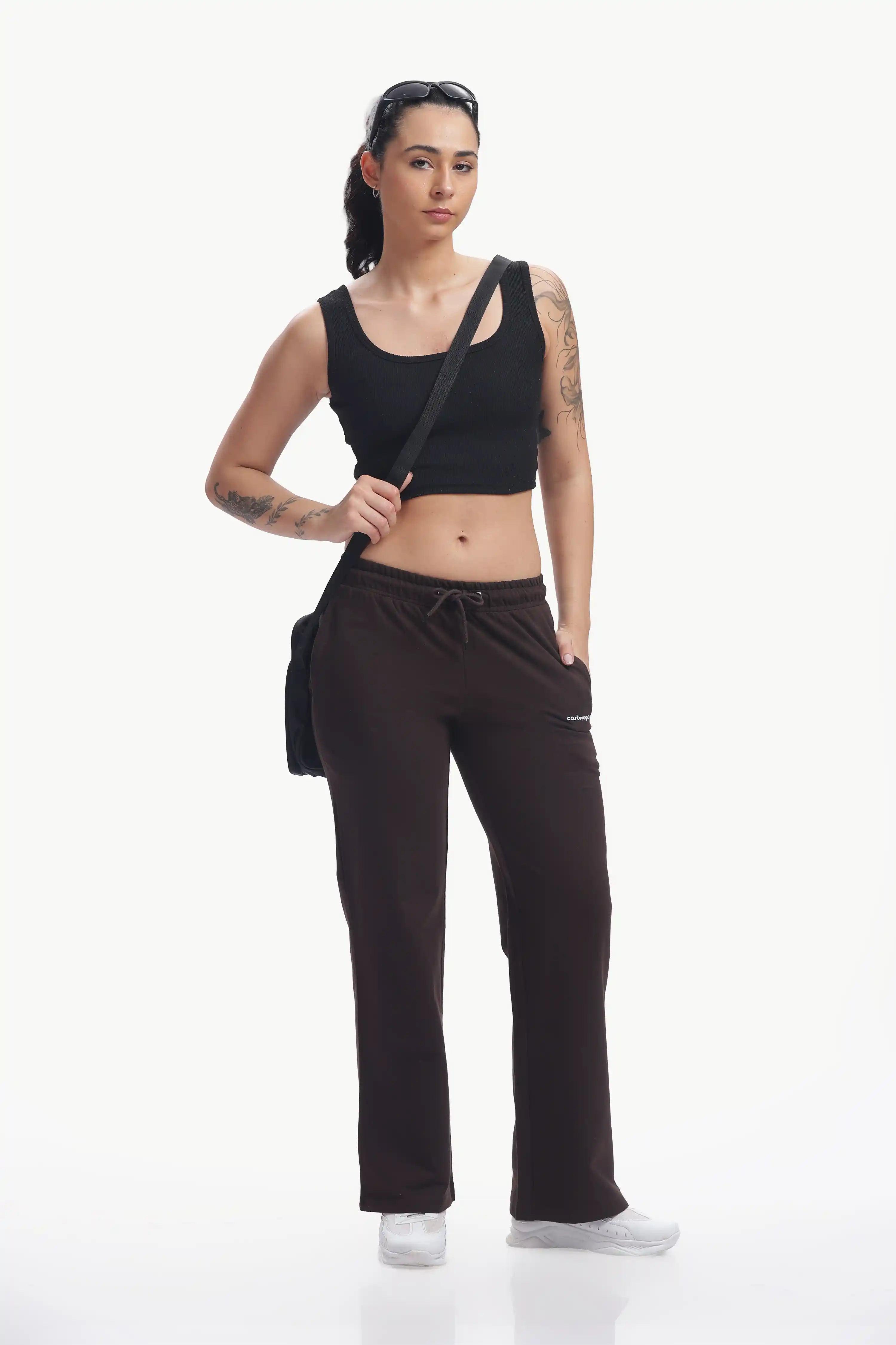Woman wearing a black tank top and pants on a white background