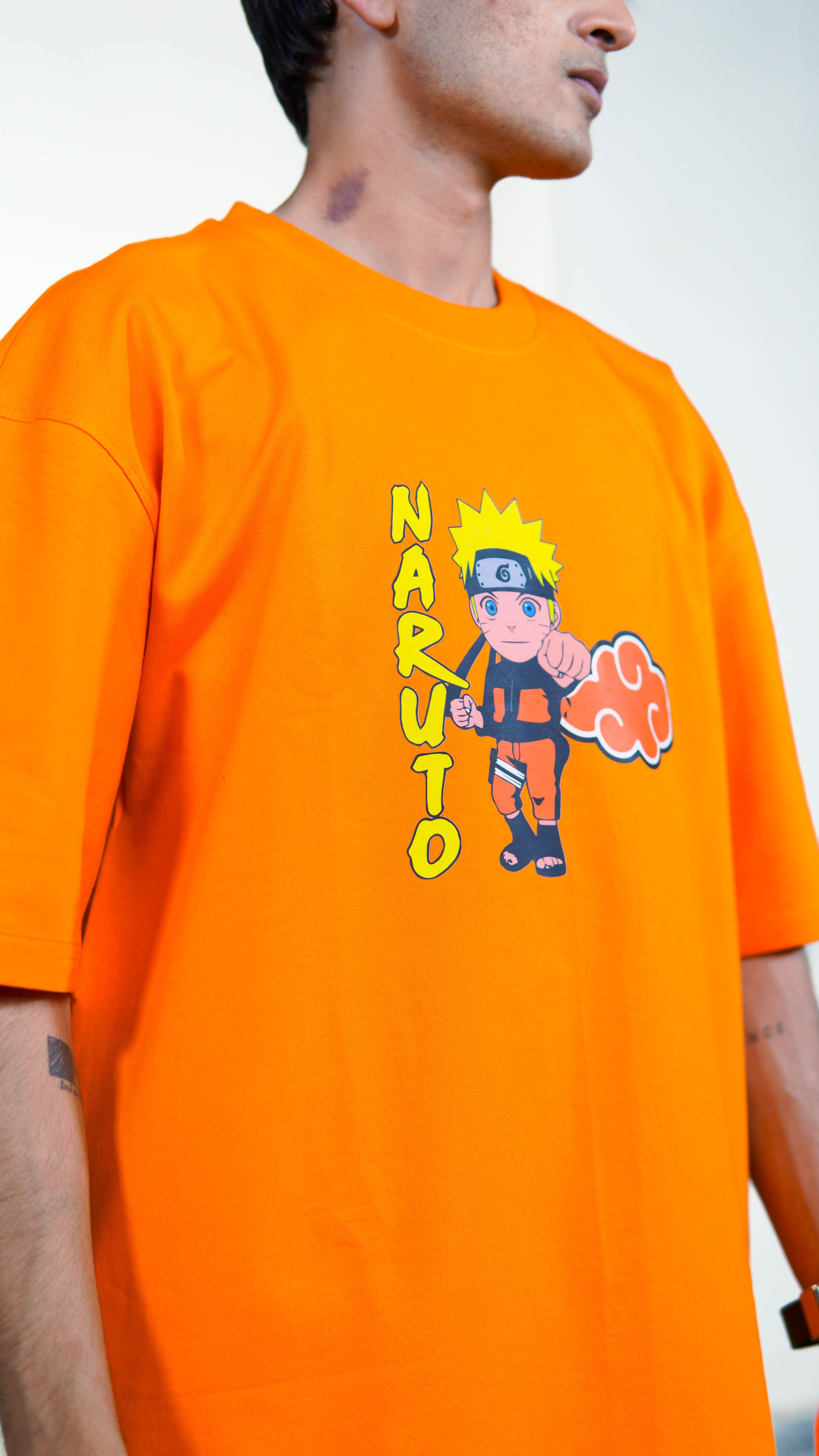 Person wearing an orange t-shirt with a cartoon naruto character
