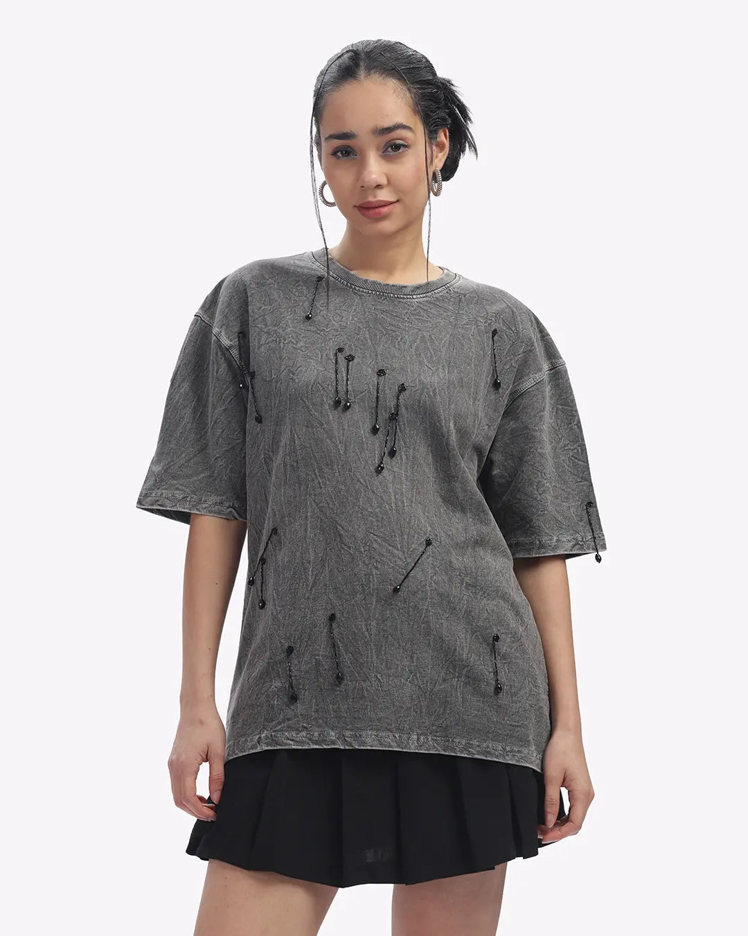 Woman wearing a gray oversized t-shirt with black accents on a white background
