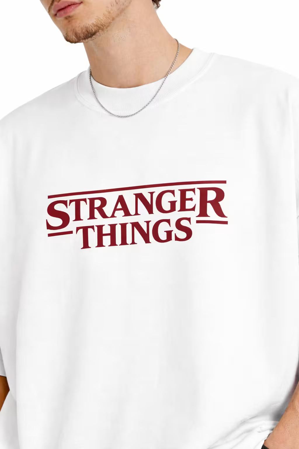 Person wearing a white 'Stranger Things' oversized t-shirt on a white background