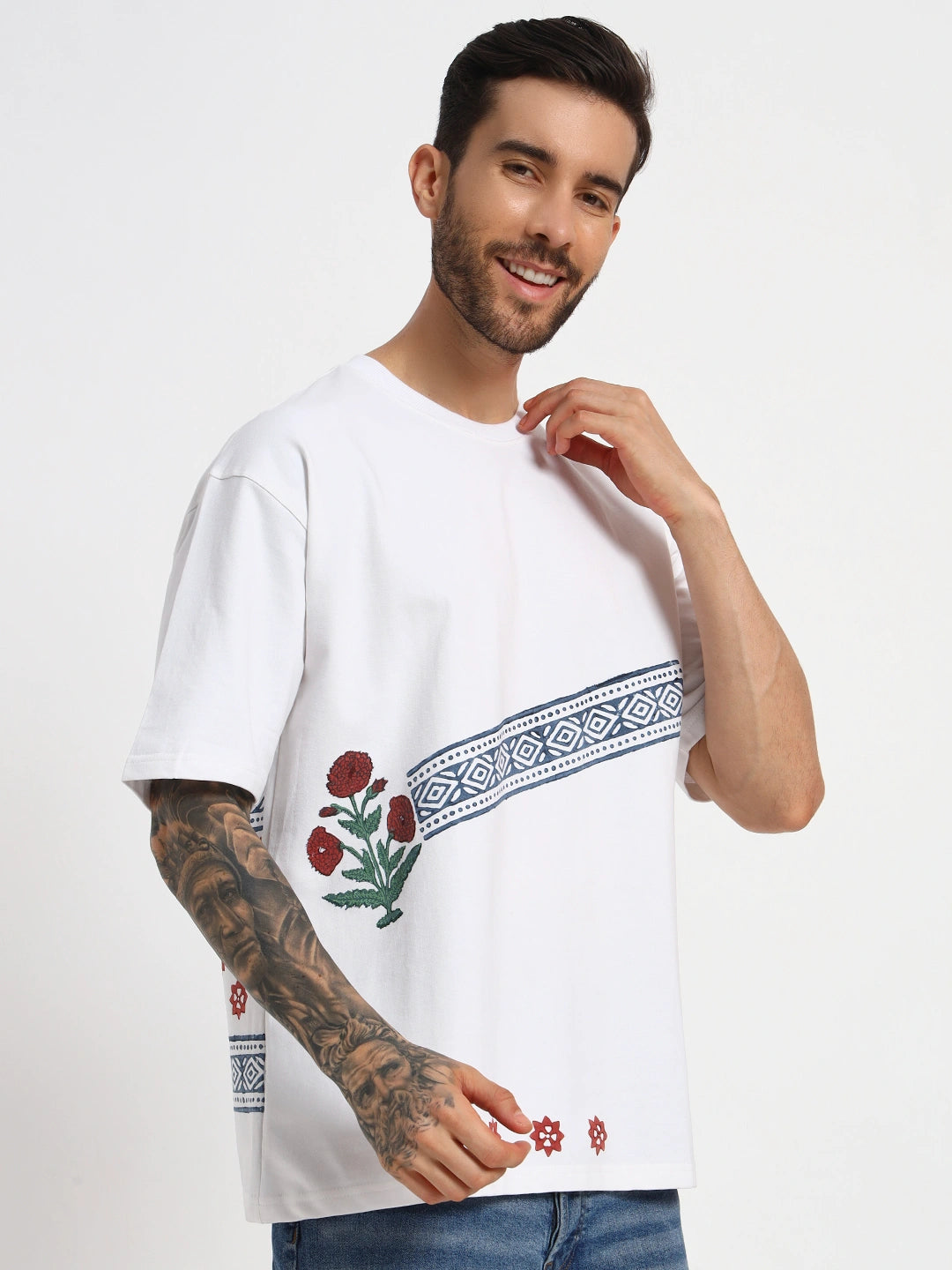 Man wearing a white t-shirt with floral embroidery on a plain background  by cartoonpanti india